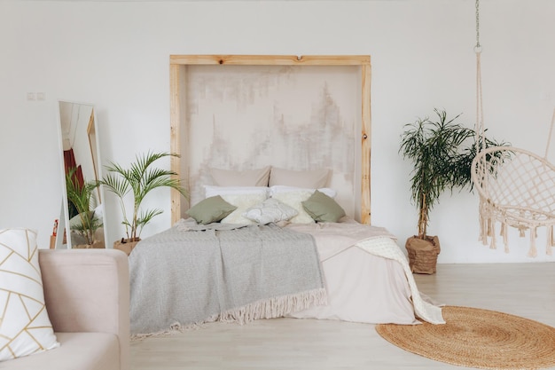 Cuscini interni della cabina su un letto di legno in un interno minimo della camera da letto con foto reale delle piante