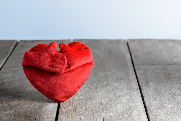 Cuscini rossi di forma del cuore su fondo di legno