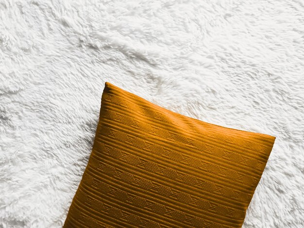 Cuscino d'oro cuscino da tiro su soffice coperta scozzese bianca come sfondo piatto camera da letto vista dall'alto e arredamento per la casa flatlay