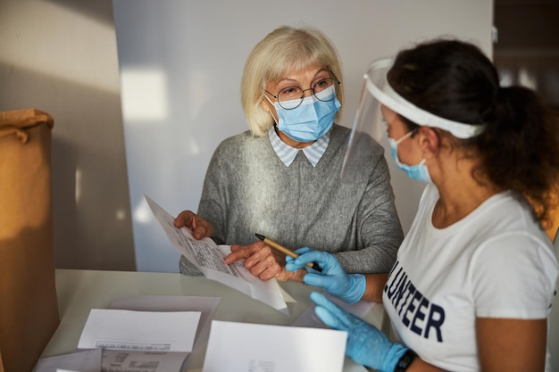 Custode che esamina una donna pensionata con una bolletta