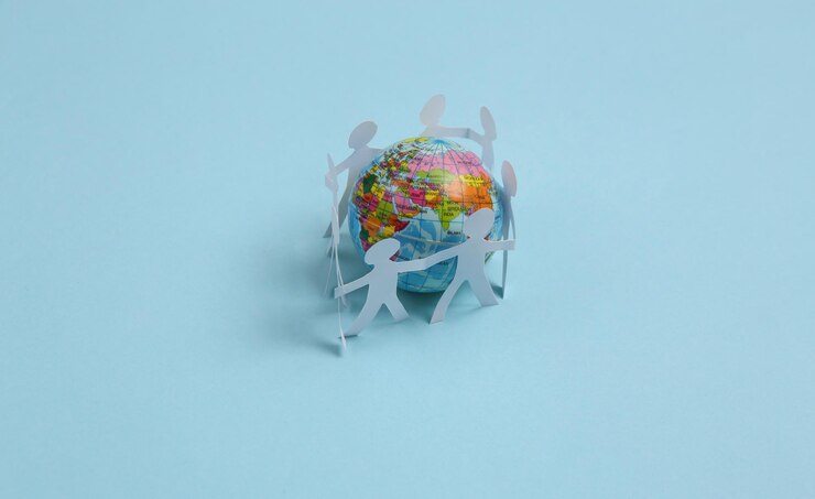 Cut paper human chain hold hands around the globexAand show their unity on blue background Solidarity and peace