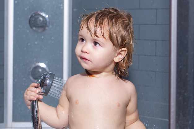Cute baby boy godendo il bagno e lavato in bagno Bambino che fa il bagno sotto una doccia I bambini divertenti affrontano il primo piano