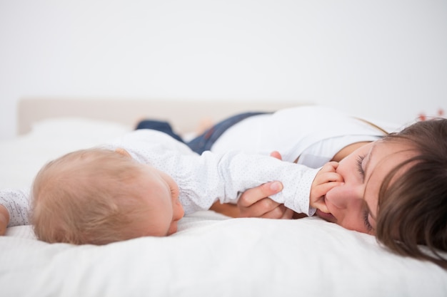 Cute baby ponendo la mano sulla bocca di sua madre