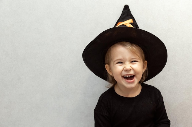 Cute bambina in un costume da strega su Halloween ride guardando nella fotocamera Spazio per il testo