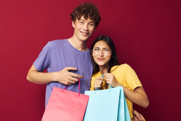 Cute giovane coppia in magliette colorate con borse Shopping isolato sfondo inalterato