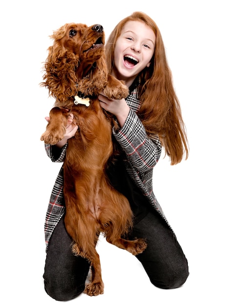 Cute giovane ragazza abbraccio cucciolo Cocker Spaniel cane Ragazza adolescente che gioca con spaniel isolato su bianco b