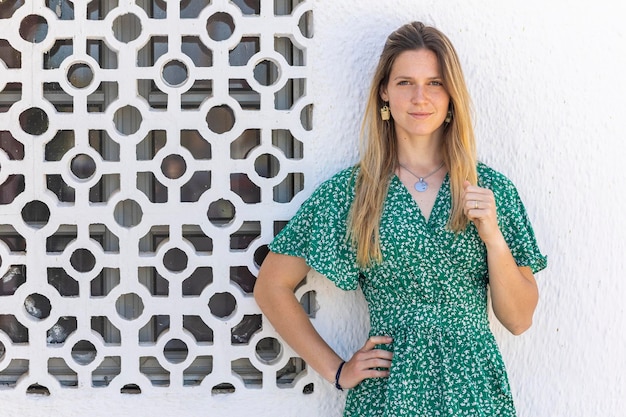 Cute ragazza bionda con abito verde su uno sfondo bianco