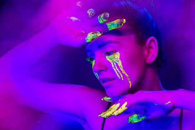 Cyberpunk Girl con trucco stilizzato alla luce delle lampade al neon