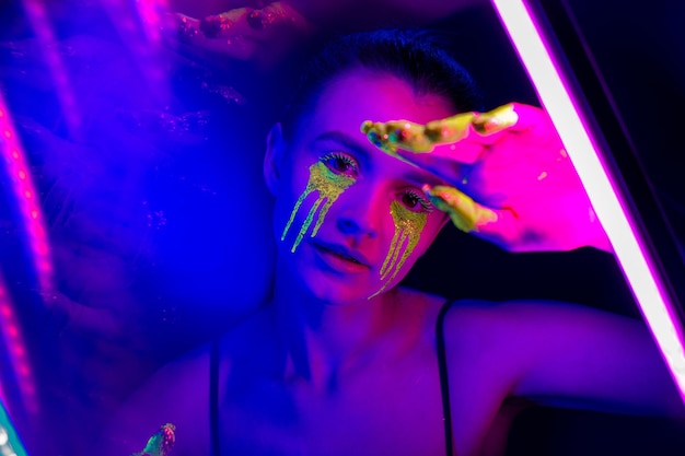 Cyberpunk Girl con trucco stilizzato alla luce delle lampade al neon