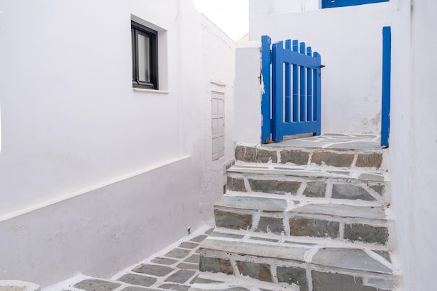 Cyclades Grecia Isola di Ios Nios Chora Costruzione in pietra bianca scale lastricate e cancello blu aperto
