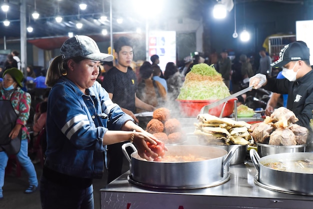 Da Lat, Vietnam - 10 febbraio 2023 donna vietnamita che cucina zuppa nel mercato notturno vietnamita con st