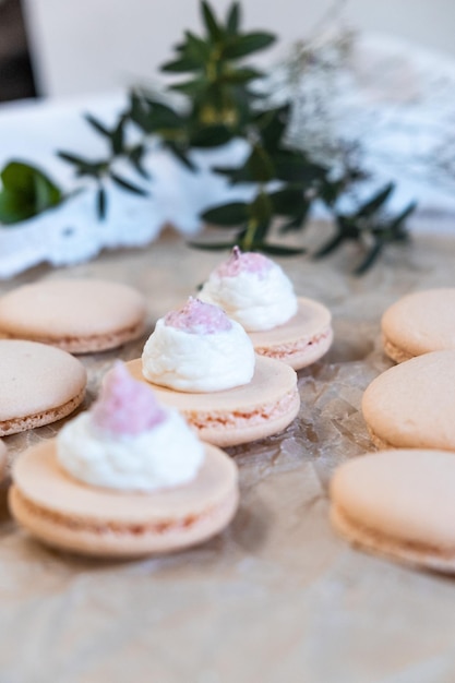 Da una tasca da pasticcere spremere la crema su metà degli amaretti a fuoco selettivo clouse up