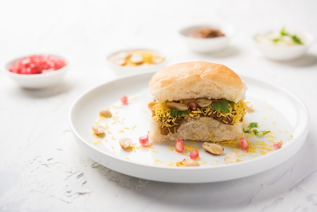 Dabeli è uno snack indiano servito con semi di melograno e coriandolo in un piatto di ceramica bianca. È un popolare cibo del Festival di Navratri