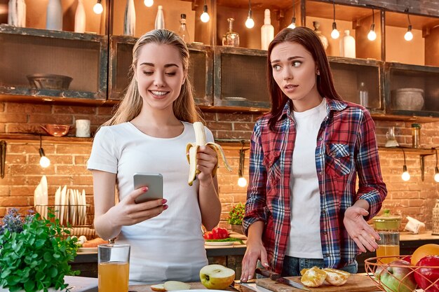 Dai al cibo spazzatura lo stivale mangia frutta giovani amiche che preparano insieme un pasto sano in