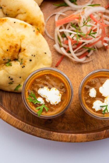 Dal Makhani o dal makhni Shots con burro e panna di fagioli naan e serviti con naan all'aglio o pane indiano o roti