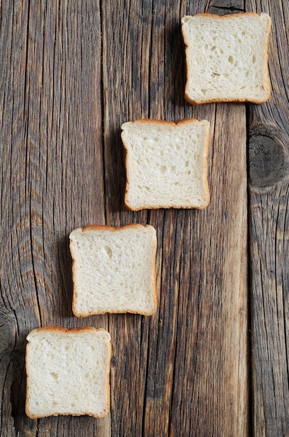 Dall'alto pezzi di mini toast contro il vecchio sfondo di legno