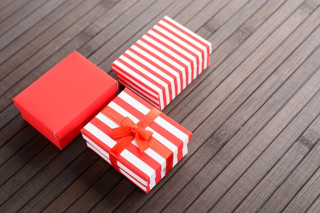 Dall'alto scatole regalo colorate rosse per Natale su un tavolo di legno.