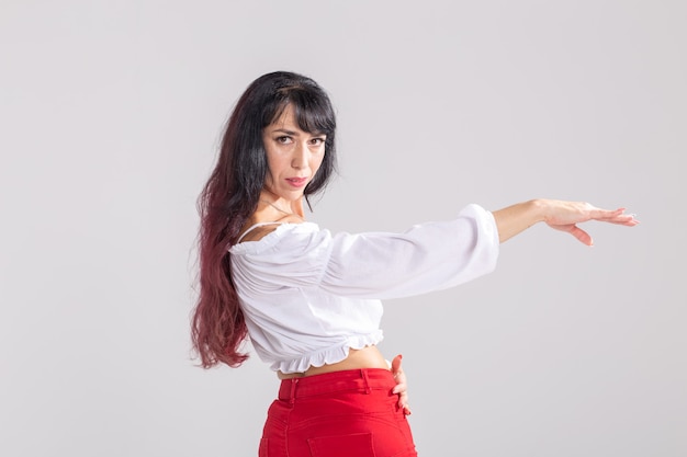 Danza latina, improvvisazione, concetto di danza contemporanea e di moda - giovane bella donna che balla su sfondo bianco studio