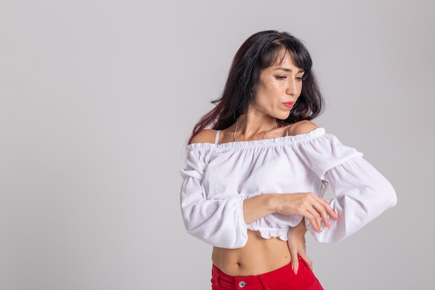 Danza latina, improvvisazione, concetto di danza contemporanea e di moda - giovane bella donna che balla su sfondo bianco studio