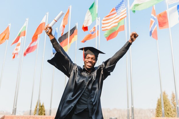 Danza maschile allegra che celebra la laurea all'aperto università, conoscenza