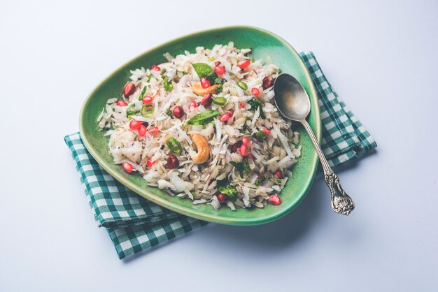 Dapde Pohe è una colazione tipica del Maharashtrian, fatta con una sottile varietà di poha e cocco fresco con peperoncino, arachidi e noci. servito in una ciotola o piatto. messa a fuoco selettiva