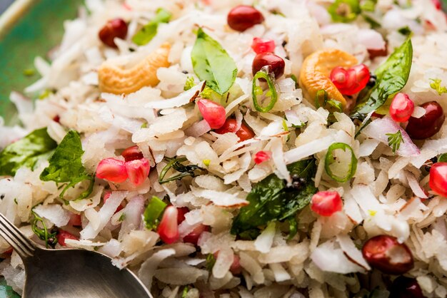 Dapde Pohe è una colazione tipica del Maharashtrian, fatta con una sottile varietà di poha e cocco fresco con peperoncino, arachidi e noci. servito in una ciotola o piatto. messa a fuoco selettiva