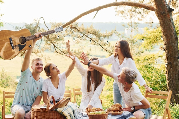 Darsi il cinque l'un l'altro Un gruppo di giovani trascorre una vacanza all'aria aperta nella foresta Concezione del fine settimana e dell'amicizia