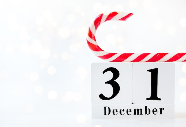 Data del nuovo anno sul calendario. Mostra calendario in legno del 31 dicembre con lecca-lecca rosso e bianco