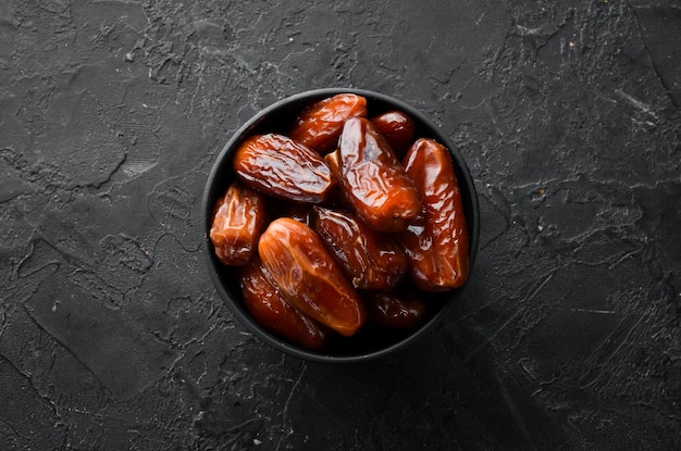 Date Deliziose date turche dolci su sfondo di pietra nera Vista dall'alto Spazio libero per il testo