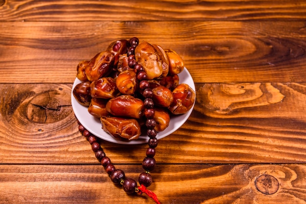 Date frutti e rosario sulla tavola di legno