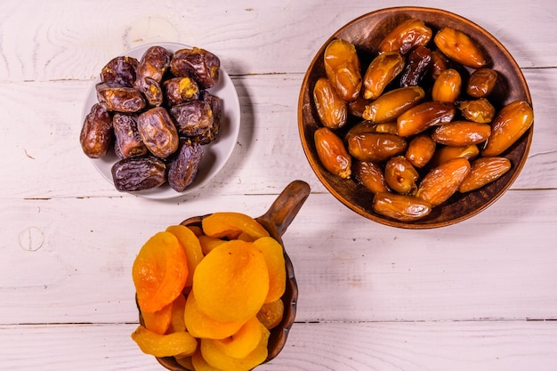 Datteri frutta e albicocche secche su tavola di legno Vista dall'alto