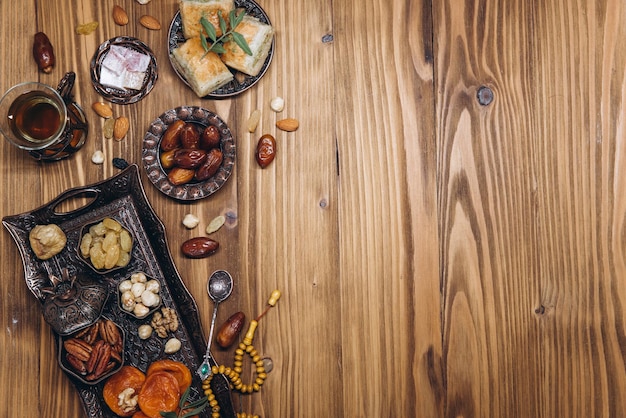 Datteri secchi e tè su un tavolo di legno Piatti tradizionali arabi pentole e datteri frutti Ramadan Kareem