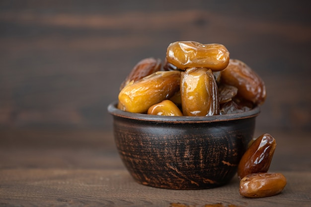 Datteri secchi frutta in una ciotola sul vecchio tavolo di legno. Vista laterale