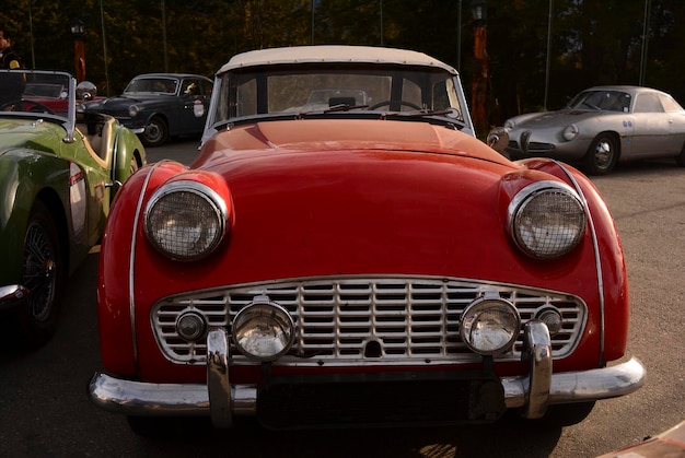 davanti a un'auto da collezione rossa, una vecchia auto d'epoca in una sfilata d'auto d'epoca
