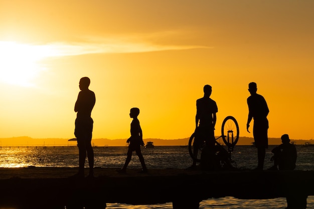 Decine di giovani in silhouette sono visti durante il tramonto in cima al ponte Crush nella città di Salvador Bahia