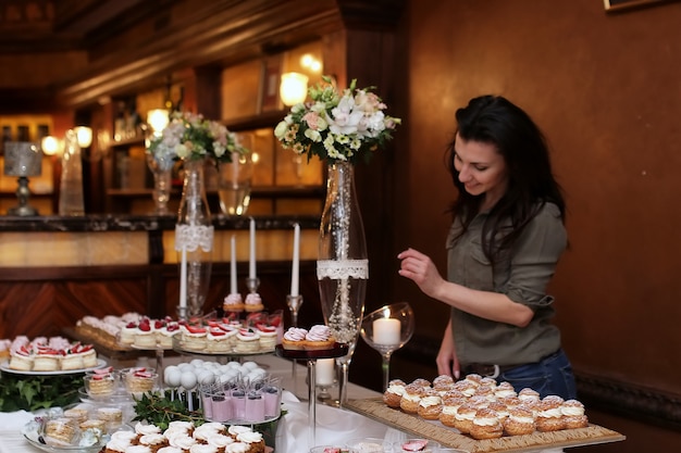 Decora una tavola festiva con dolci e una varietà di snack dolci sullo sfondo di una pasticcera