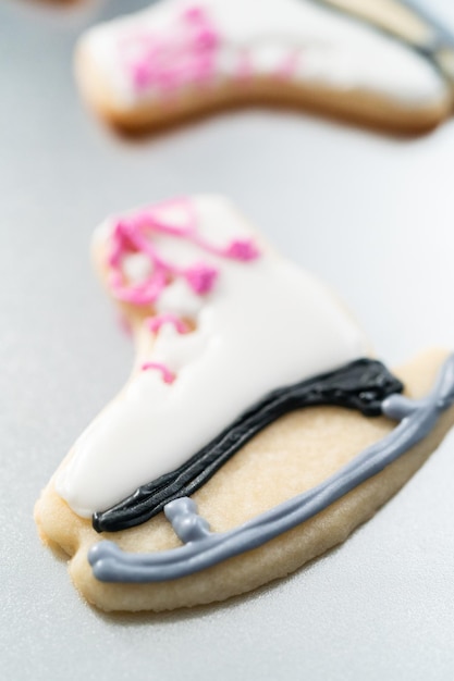 Decorare biscotti di zucchero a forma di pattini con ghiaccia reale.