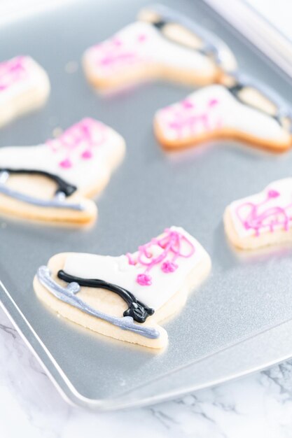 Decorare biscotti di zucchero a forma di pattini con ghiaccia reale.