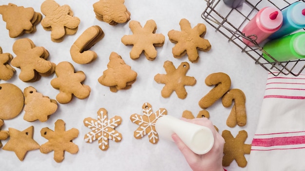 Decorare i biscotti di panpepato con la ghiaccia reale per Natale.