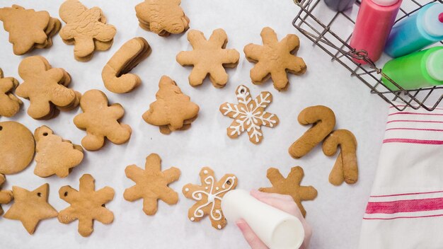 Decorare i biscotti di panpepato con la ghiaccia reale per Natale.