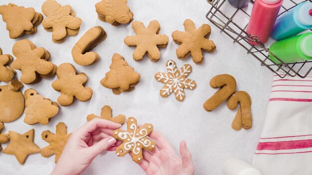 Decorare i biscotti di panpepato con la ghiaccia reale per Natale.