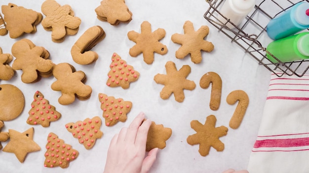 Decorare i biscotti di panpepato con la ghiaccia reale per Natale.