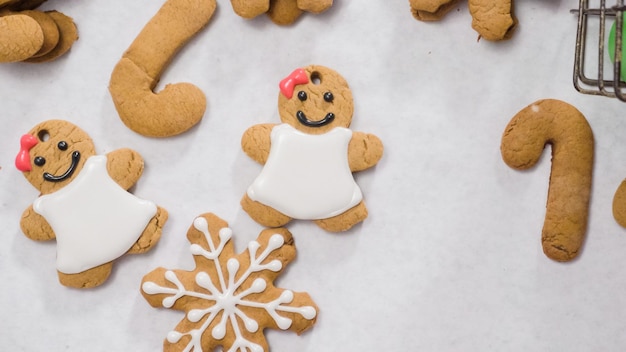 Decorare i biscotti di panpepato con la ghiaccia reale per Natale.