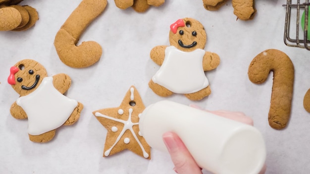 Decorare i biscotti di panpepato con la ghiaccia reale per Natale.