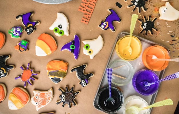 Decorare i biscotti di zucchero di Halloween con la glassa reale colorata.