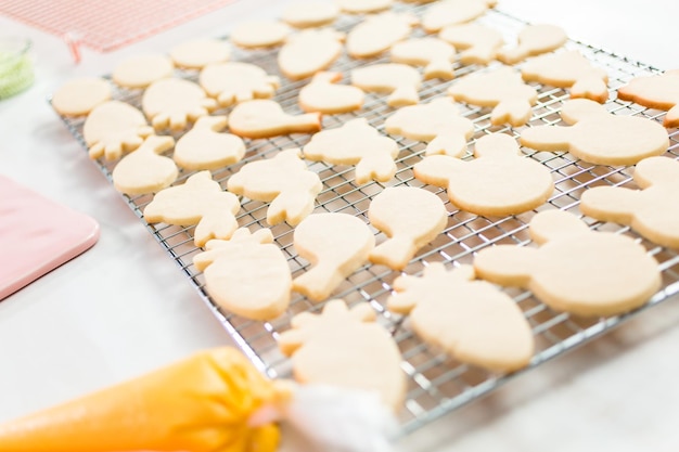 Decorare i biscotti pasquali di zucchero con la glassa rotal.