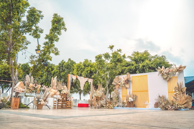 Decorare l'arco con fiori e stoffa per una cerimonia di matrimonio nella natura Cerimonia di matrimonio con fiori all'esterno in giardino con luci sospese