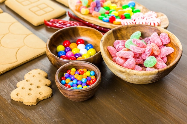 Decorare la casa di marzapane con ghiaccia reale e caramelle colorate.