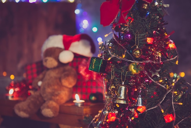 Decorare per lo sfondo natalizio La bambola dell'orsacchiotto sfocata indossa il cappello di Natale