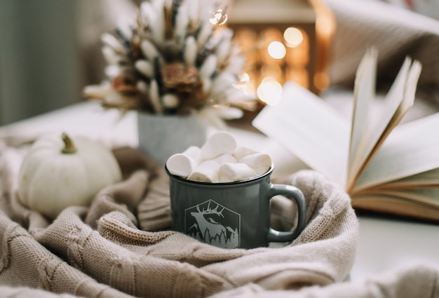 Decorazione autunnale stagionale per la casa con tazza di caffè e fiori secchi e zucca bianca e un libro